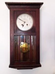 Relógio de parede com caixa em madeira, mostrador em cartão, badalo em metal dourado, porta com vidro. Manufatura Vedette. Necessita regulagem, mostrador com desgastes. 65 x 37 x 20cm.