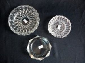 Três cinzeiros em vidro translúcido moldados com diferentes geométricos. Diâms. 10, 10 e 14cm.