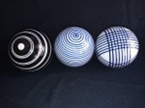 Três bolas decorativas em cerâmica vitrificada, decoração de linhas policromadas azuis, brancas e pretas. Alt. 8cm.