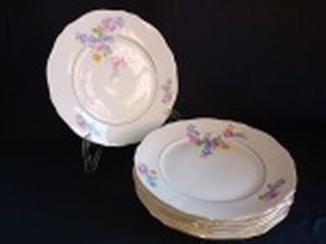 Seis pratos rasos em porcelana polonesa decorada com flores em policromia e frisos à ouro. Marca da Manufatura Koenigszelt. Íntegros. Diam. 25cm.