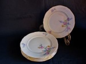 Seis pratos para sobremesa em porcelana polonesa decorada com flores em policromia e frisos à ouro. Marca da Manufatura Koenigszelt. Íntegros. Diam. 19,5cm.