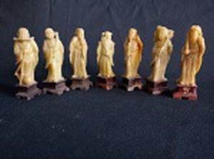 "Os 7 Deuses da Felicidade" sete estatuetas chinesas esculpidas em pedra dura representando individualmente cada um dos deuses. Bases também em pedra dura escura. Alt. do maior 8cm.