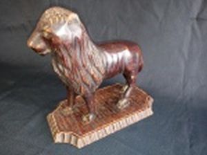Escultura de leão confeccionada em madeira entalhada. Pés quebrados e soltando da base. 21 x 22 x 12cm.