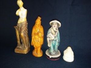 Quatro estatuetas: sábio chinês em gesso, 12cm, lascados; figura greco-romana feminina, pátina em dourado, 17cm; velho chinês, em gesso patinado de marrom, 12cm; e figura de buda em resina, 3cm.