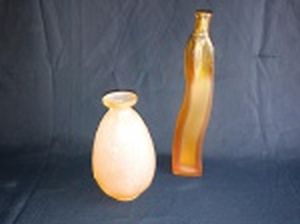 Solifleur e vaso bojudo em vidro fosco, sendo em formato ondulado âmbar e um rosé com folhagens em alto relevo. Alts. 24 e 16cm.