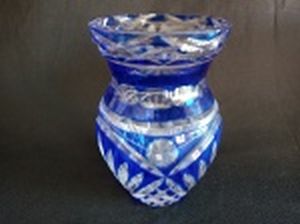 Vaso em cristal da Boemia, overlay azul lapidado com frisos e geométricos. lascado na borda e bicados na base. Alt. 15cm.
