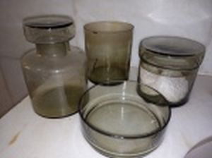 Conjunto para banheiro em vidro fumê translúcido: frasco, pote com tampa e 2 potes sem tampa (1 com trincado). Alt. do maior 14cm.