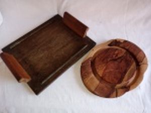Duas peças em madeira: a) Bandeja retangular. Selo no fundo da loja Merci... 35 x 28cm. b) Tábua para queijo (falta a tampa). 29 x 22cm.