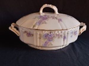 LIMOGES, França - Sopeira em porcelana branca francesa, formato oblongo, borda e alças filetadas a ouro, com modelagem na pasta formando acantos em alto relevo, decorada por arranjos de flores azuis e folhagens. Apresenta leves desgastes do tempo, sobretudo nas perdas da douração. Marcado no fundo com selo da Casa Vianna, primeira metade do século XX. 19 x 35 x 22cm.