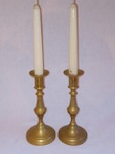 Par de castiçais em  bronze polido, base redonda, haste balaústre. Alt. 19cm. Alt. com as velas 35cm.