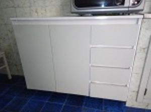 Armário em madeira brasileira forrada com fórmica branca, 4 gavetas e 2 portas, interior com 1 prateleira. Vestígios de ataque de cupins. No estado. 90 x 110 x 40cm.