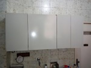 Armário de parede, madeira brasileira forrada com fórmica branca, 4 portas, interior com 1 prateleira. Pequeno quebrado em 1 porta e fórmica necessitando colar em algumas partes. Vestígios de ataque de cupins. No estado. 61 x 141 x 35cm.