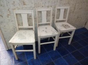Três cadeiras de madeira brasileira pintadas de branco, encosto vazado com amarração central. No estado, necessita ajustes e pintura. Alt. 78cm.