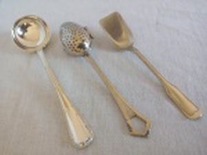 Três colheres em metal espessurado a prata: a) Concha para molhos, cabo moldado no padrão lacinho. Manufatura Fracalanza. Comp. 15cm. b) Colher coador de chá, Art Deco, marcada W.M.F.. Comp. 14,5cm. c) Colher para açúcar, cabo no padrão clássico, marcada Alpacca Wolff. Comp. 13cm.