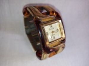 Relógio de pulso a quartzo, feminino, caixa em acrílico, pulseira em metal e acrílico. Marcado Jéssica Carlyle. No estado, usado e sem garantias.