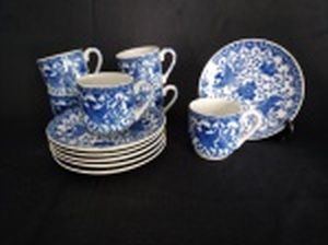 Seis xícaras para café com respectivos pires, porcelana japonesa branca decorada com aves e frutos em azul.