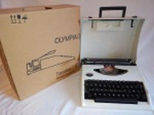 Máquina de datilografia portátil, manufatura Olympia, modelo Traveller. Embalagem original. Necessita revisão no mecanismo. 10 x 30 x 31cm.