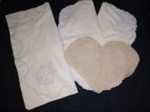 Quatro capas para almofadas, 3 com bordados e 1 em crochê na forma de coração. Maior 68 x 68cm.
