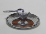 Quebra-nozes de mesa em metal cromado, prato em resina prateada, centro aplicado por madeira. 9 x 20cm.