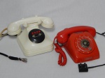 Dois antigos telefone em baquelite, sendo um em vermelho da Erickson com dial em disco, e um branco para comunicação em sistema interno. Ambos com funcionamento desconhecido. 11 x 23 x 19cm e 18 x 23 x 17cm.