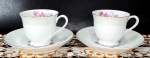 MADE IN JAPAN - Par de xícaras para café em porcelana de harmoniosa combinação nos tons branco/verde bebê e pintura em ouro com filetações nas alças e bordas, além da decoração de rosas em sutil policromia. Medem 5,5 x 6,5 cm as xícaras e 12 cm de diâmetro os pires.