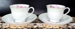 MADE IN JAPAN - Par de xícaras para café em porcelana de harmoniosa combinação nos tons branco/verde bebê e pintura em ouro com filetações nas alças e bordas, além da decoração de rosas em sutil policromia. Medem 5,5 x 6,5 cm as xícaras e 12 cm de diâmetro os pires.