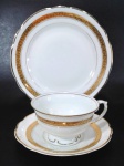 PORCELANA REAL - Trio para chá e bolo em porcelana branca com faixa dourada de arabescos e filetação em ouro nas bordas. Medem 6 x 9,5 cm a xícara, 14,5 cm de diâmetro o pires e 18,5 cm de diâmetro o prato para bolo.