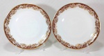 MON CHÉRI RENNER - Belo par de pratos dito rasos em porcelana branca ricamente decorada por faixa de tom avelã sob flores e ramagens douradas, além de filetação em ouro na borda. Medem 25 cm de diâmetro cada.