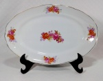 PORCELANA REAL S. PAULO - Travessa rasa em porcelana branca decorada por rosas e ramagens em policromia além de filetação dourada nas bordas. Medem 33 cm de comprimento e 21 cm de largura cada.