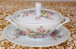 PORCELANA SCHMIDT - Belo açucareiro com presentoir em porcelana Schmidt em porcelana branca oval decorada por rosas e flores em policromia. Mede 8 cm de altura por 14,5 cm de comprimento.