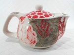 Pequena chaleira / bule colecionável em porcelana decorada por rosas e flores em policromia - possui difusor em aço inox - mede 9 cm de altura por 15 cm de comprimento e 9 cm de largura.