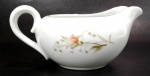 PORCELANA MINO - MADE IN JAPAN - Cremeira em porcelana branca decorada por flores e ramagens em sutil policromia e filetação prata.  Mede 7 cm de altura por 15 cm da alça ao bico.