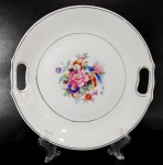 PORCELANA RAMI -  Grande prato para bolo em porcelana decorada por arranjos florais em policromia e pegas vazadas. Mede 26 cm de diâmetro.