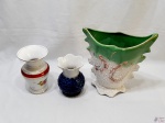 Lote composto de 3 vasos em porcelana, sendo o maior trabalhado com relevos e medindo 27,5cm de altura.