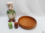 Lote composto porta talher de servir na forma de cozinheiro em porcelana, travessa redonda em madeira, saleiro e pimenteiro em porcelana. Medindo o cozinheiro 25cm de altura.