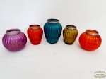 5  castiçais  de Vidro Colorido com Velas. 1 Apresenta Quebrado conforme foto. Medidas Maior 13 cm altura x 6 cm diametro; medio 10,5 cm altura x 5,6 cm diametro e Pequeno 10 cm altura x 5,5 cm diametro.