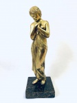 Escultura em bronze dourado representando mulher, com base em mármore. Med. 40 cm. 