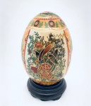 Ovo em porcelana ao gosto Satsuma decorado com aves, acompanha peanha para suporte. Med. 13x8 cm.