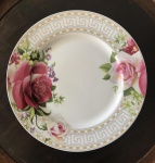 Prato em porcelana branca decorado com rosas e detalhes em ouro. Med. 27 cm.