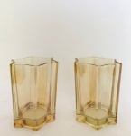 Dois Porta velas em vidro na tonalidade dourada, em formato de estrela. Med. 9x8 cm.