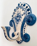 Cabideiro em faiança pintado à mão decorado com flores em tom azul. Med. 24x19 cm.