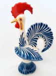 Galo de Barcelos em cerâmica, decorado com pintura em tom azul. Med. Alt. 34 cm.