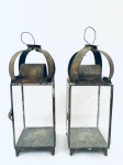 Par de Lanternas para velas em metal, com laterais em vidro, alça e porta com fecho. Med. 33x12x12 cm.