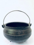 Caldeirão em ferro, apoiado por três pés, com alça. Med. Diâm. 24 cm. Alt. 14 cm.