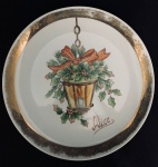 Prato em porcelana branca, decorado com arranjo e dizer Alice, com desgastes na pintura da borda. Med. Diâm. 24 cm.