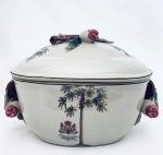 Centro de mesa oval com tampa em porcelana, decorado com coqueiros e ornado com flores em relevo nas pegas laterais e na tampa. Med. 21x30x16 cm.
