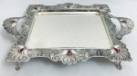 Bandeja em metal, fundo cinzelado, bordas decoradas com arabescos em relevo, duas pegas laterais. Med. 45x30 cm.