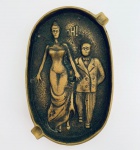 Cinzeiro em bronze decorado com figura erótica, em sua frente e em seu verso. Med. 13x8 cm.