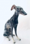 Escultura Cão da raça Galgo, confeccionada em faiança, na cor cinza. Med. 44x33 cm.