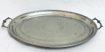 Bela bandeja oval, manufatura WMF, em metal, pegas nas laterais, com pequenos desgastes. Med. 51x31 cm.